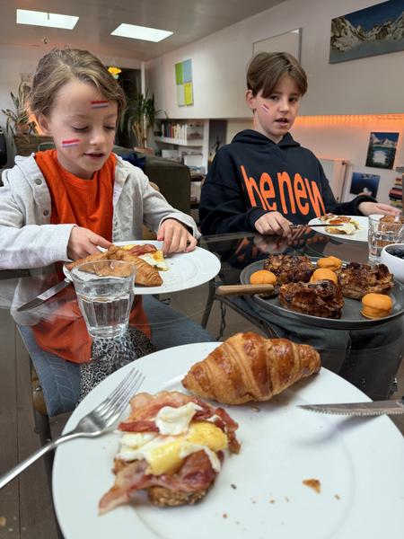 Two children eating breakfast indoors at a cafe